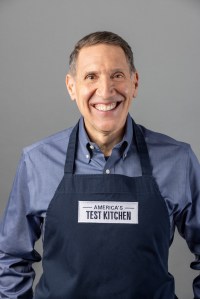 A man wearing an apron smiling at the camera