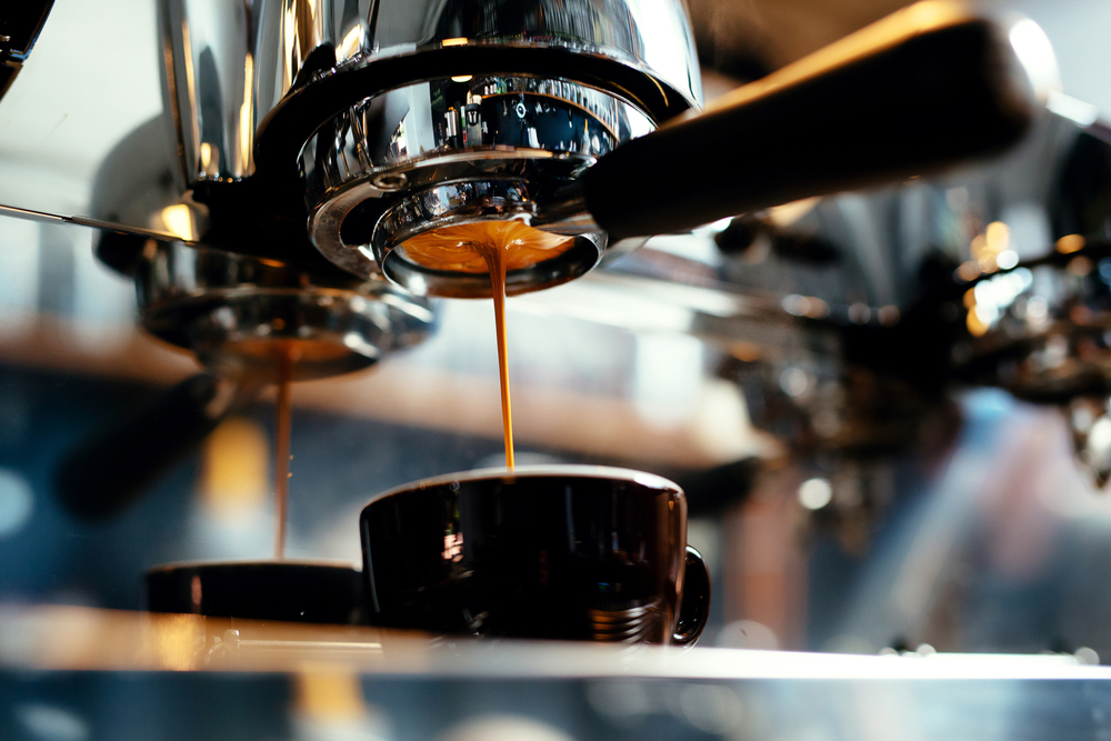 an espresso machine dripping espresso into a cup