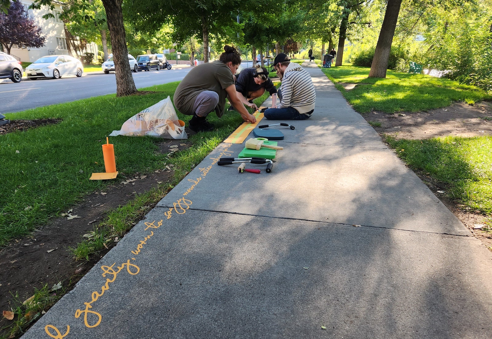 Three people measure the side of a sidewalk and write poetry along its edge.