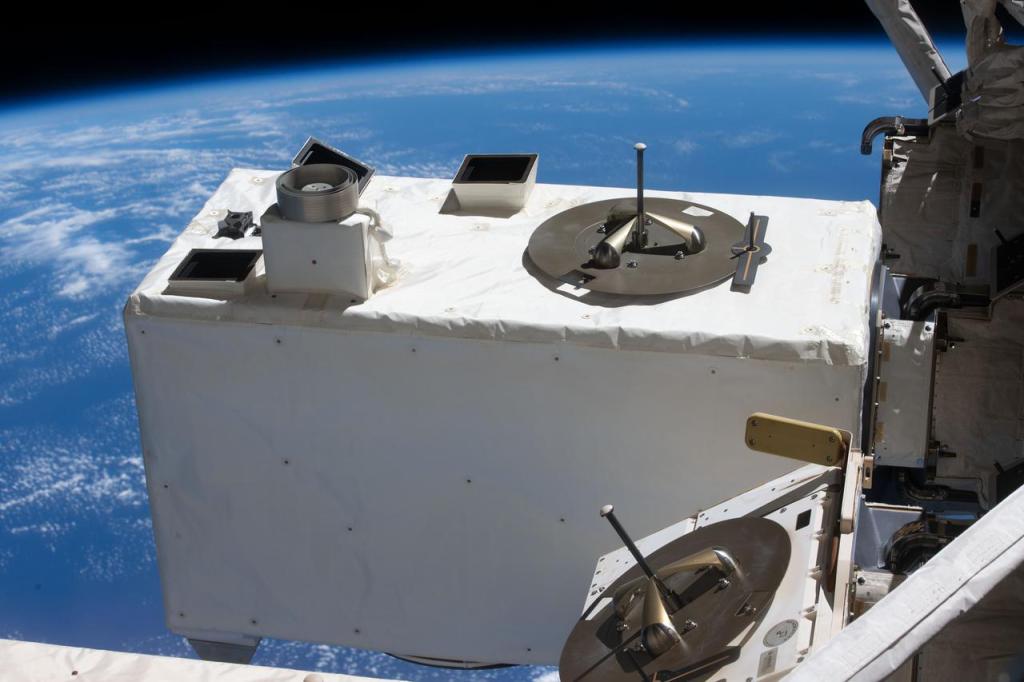 A large white box attached to the ISS on the right side, set against the blue backdrop of Earth.