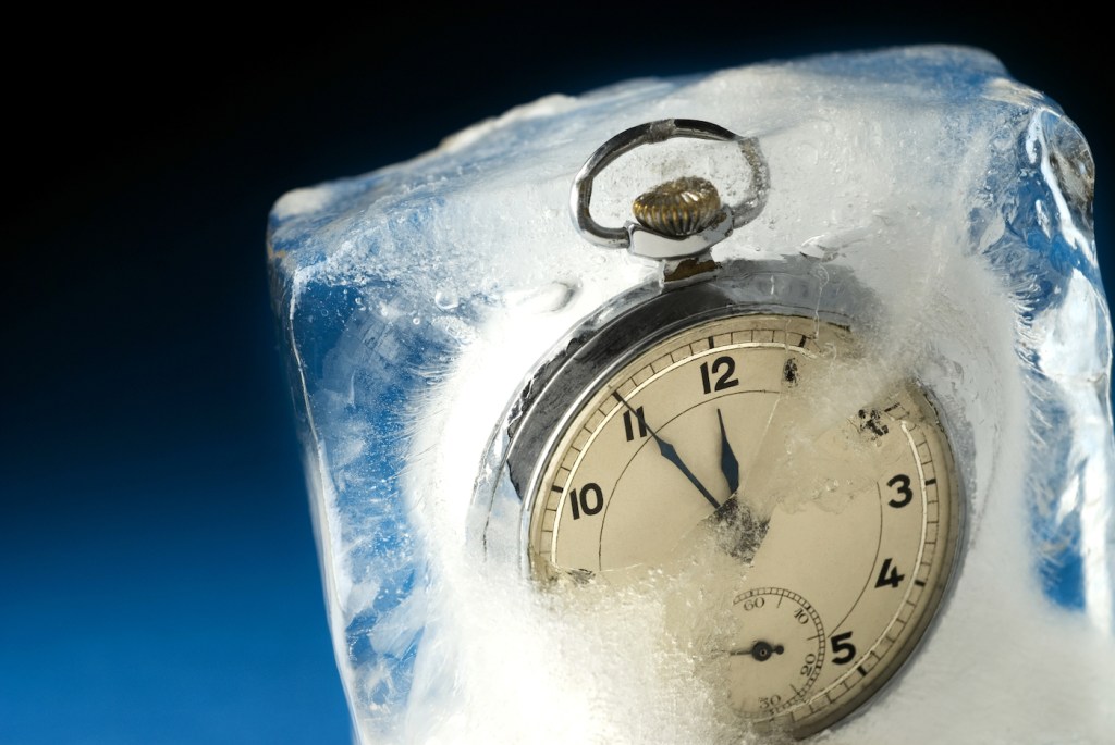 A pocket watch frozen in a block of ice.