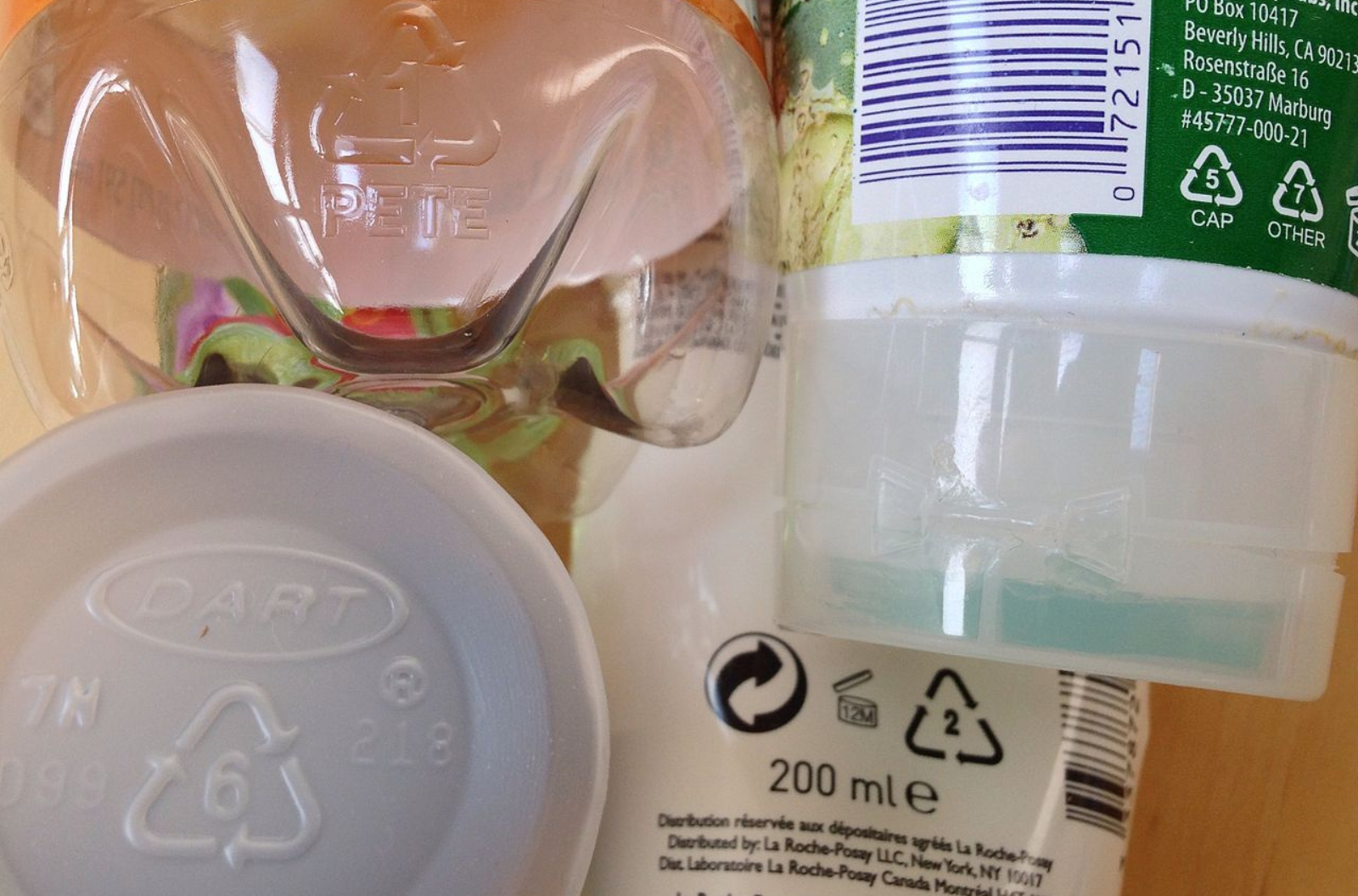 A variety of plastic containers all with recycling codes showing a number centered in a triangle with arrows.