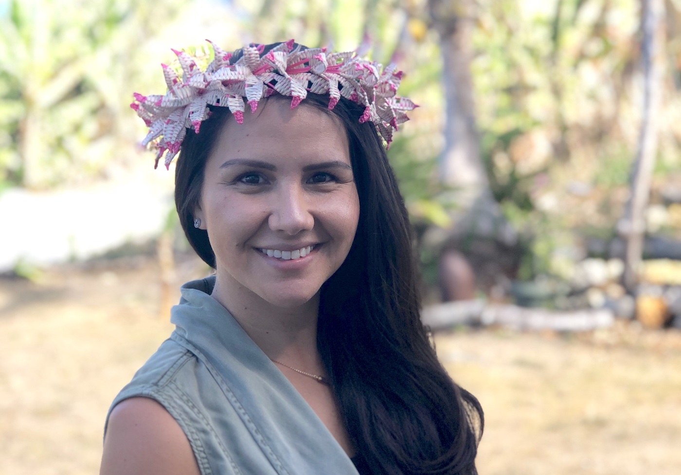 A woman wearing a floral headband looks at the camera.