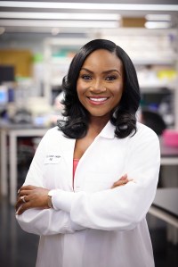 A Black woman wearing a lab coat in a lab.