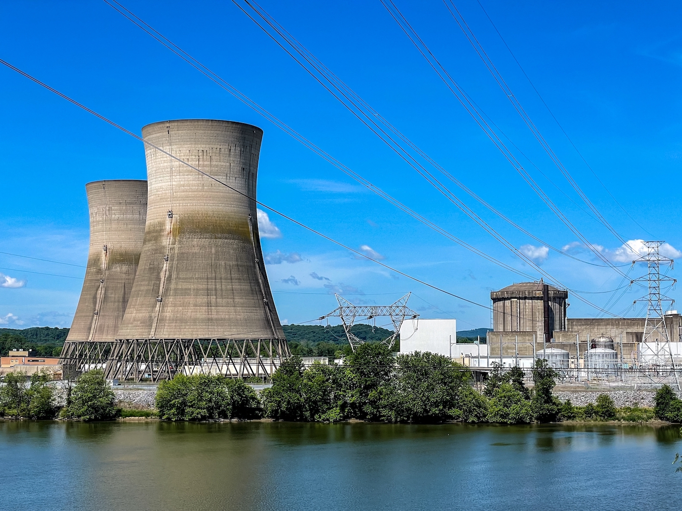 A nuclear power plant, large buildings like concave cylinders by a body of water.