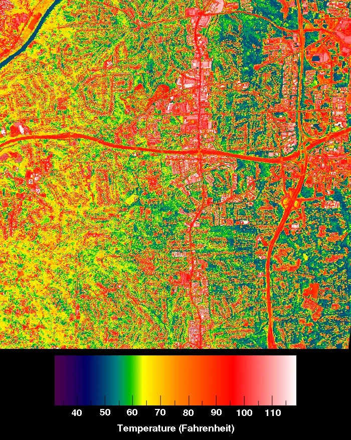 A thermal map of Chicago captured by sensors on the ISS. The map uses a color spectrum to represent surface temperatures, with a legend at the bottom indicating temperatures from 40°F (deep blue/purple) to 110°F (white). The map reveals a complex pattern of heat distribution across the urban landscape. Red and white areas, indicating the highest temperatures are prominent along major roads and in densely built-up areas, likely commercial or industrial zones. Yellow and light green areas are widespread, representing residential neighborhoods with a mix of buildings and vegetation. Dark green and blue areas are less common but visible in patches, likely corresponding to parks, water bodies, or areas with dense vegetation. The image clearly illustrates the urban heat island effect, where man-made structures and surfaces retain more heat than natural landscapes.