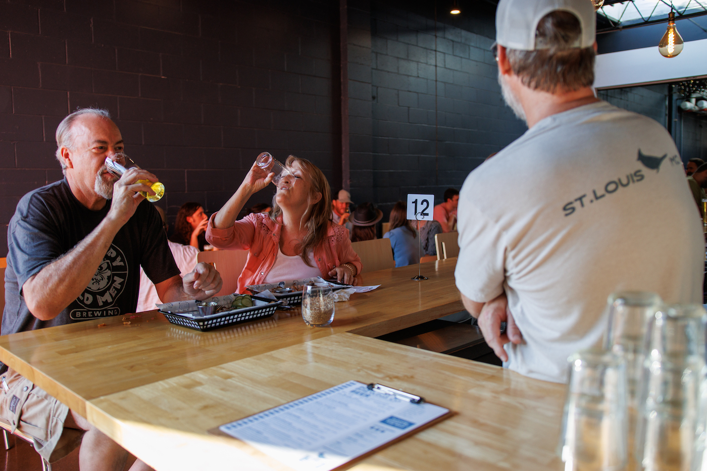 A man and woman finish their beers at a bar.