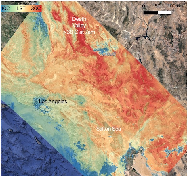 This image shows a land surface temperature (LST) map of Southern California, focusing on the area from Los Angeles to Death Valley. The map uses a color scale ranging from blue (coolest) to red (hottest), with temperatures between 10°C and 30°C. A scale bar in the top right indicates 0 to 50 to 100 km distances. Los Angeles appears in cooler blue tones near the middle left. Death Valley is marked as the hottest area in bright red, with a label indicating >33°C at 7 a.m.. The Pacific Ocean is visible in dark blue on the bottom left. The right side of the image shows the natural terrain in gray scale, contrasting with the colorized temperature data.