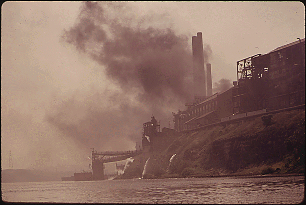 A polluting factory dumps waste into the air and water.