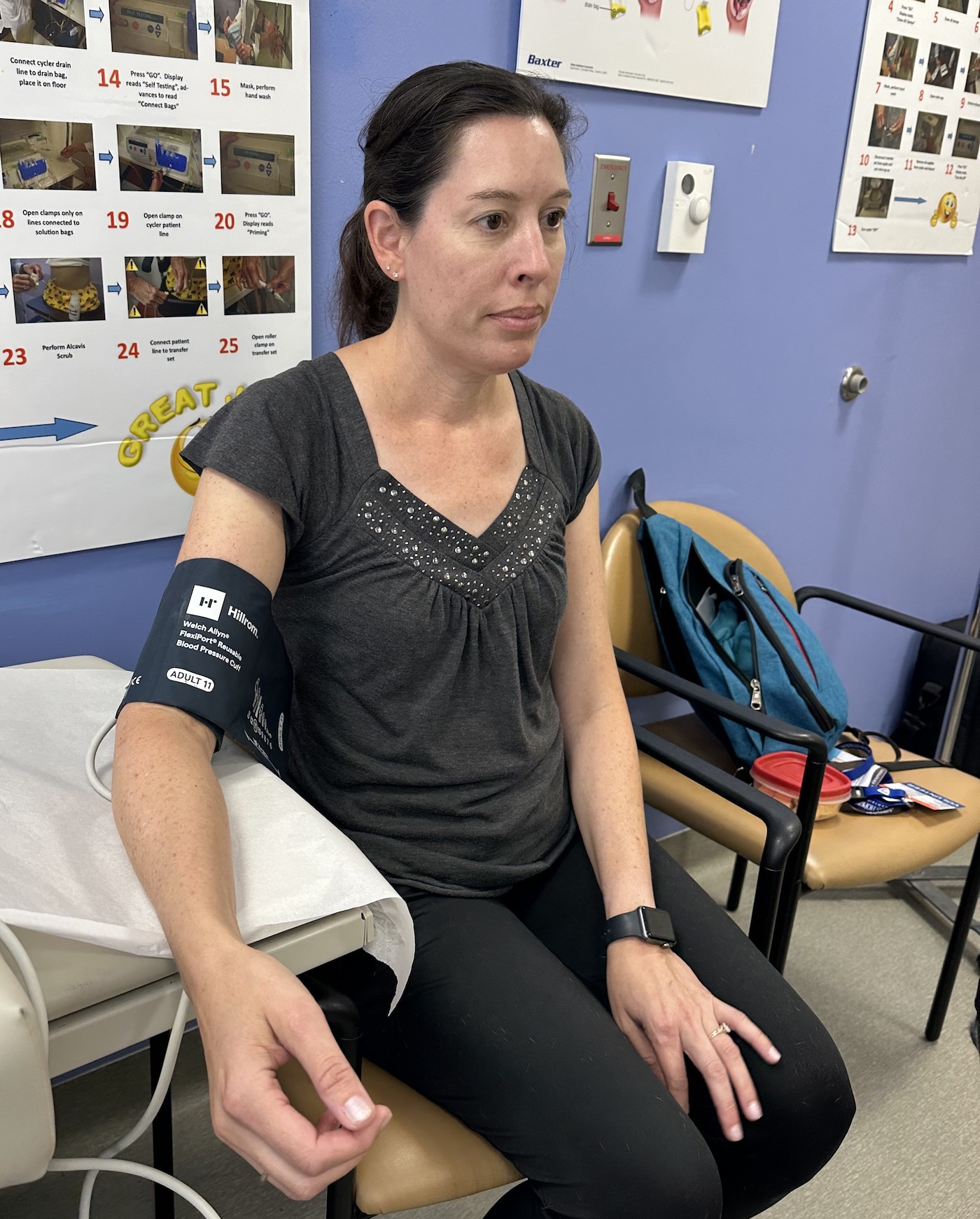 A woman's arm with a blood pressure monitor around it.