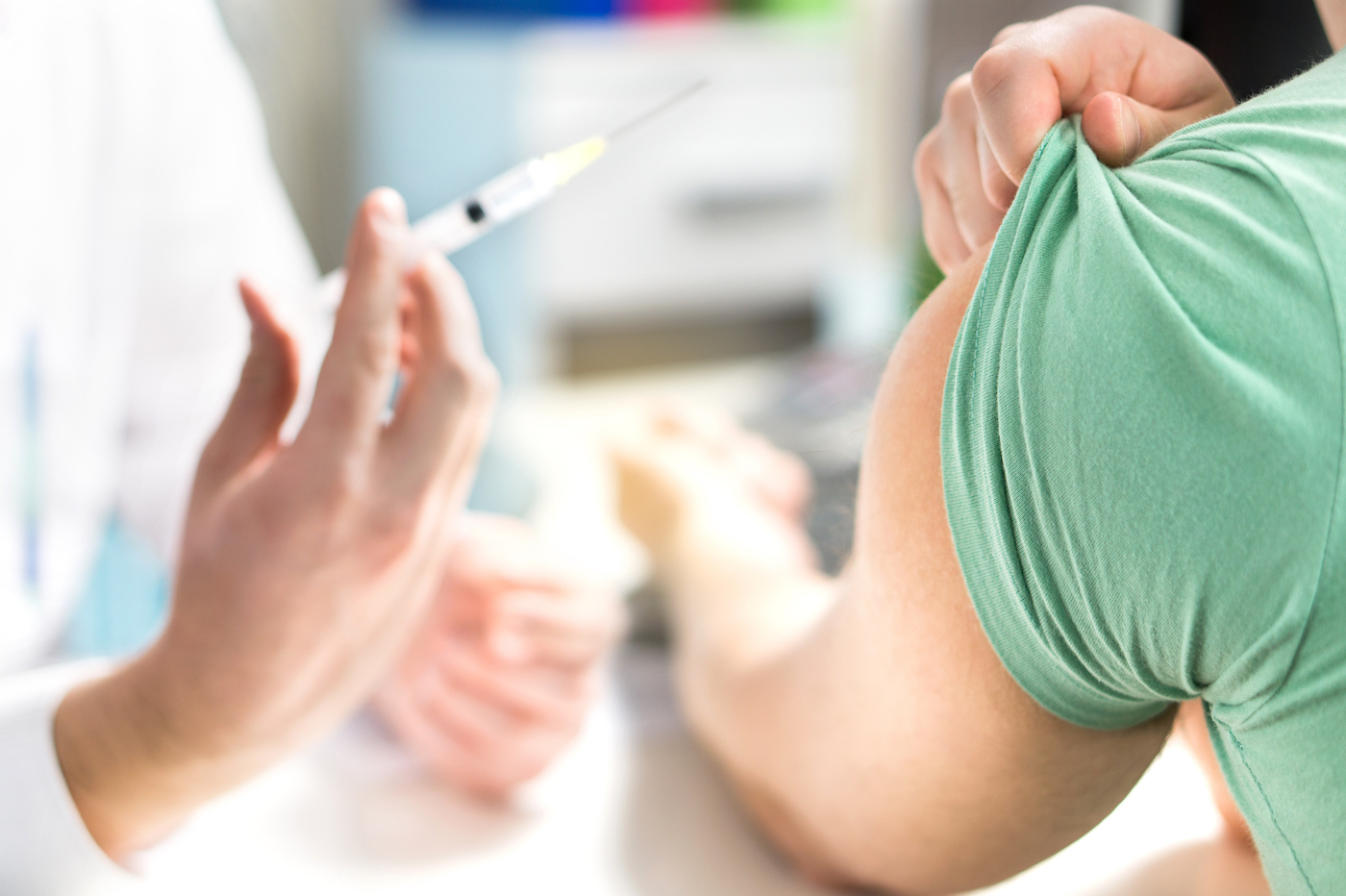 Doctor giving patient vaccine, flu or influenza shot or taking blood test with needle. Nurse with injection or syringe. Medicine, insulin or vaccination. Hospital office room.